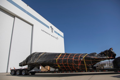 High-security freight tarped on specialized trailer.